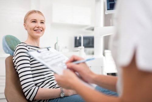 Patient Sitting In Front Of Her Dentist